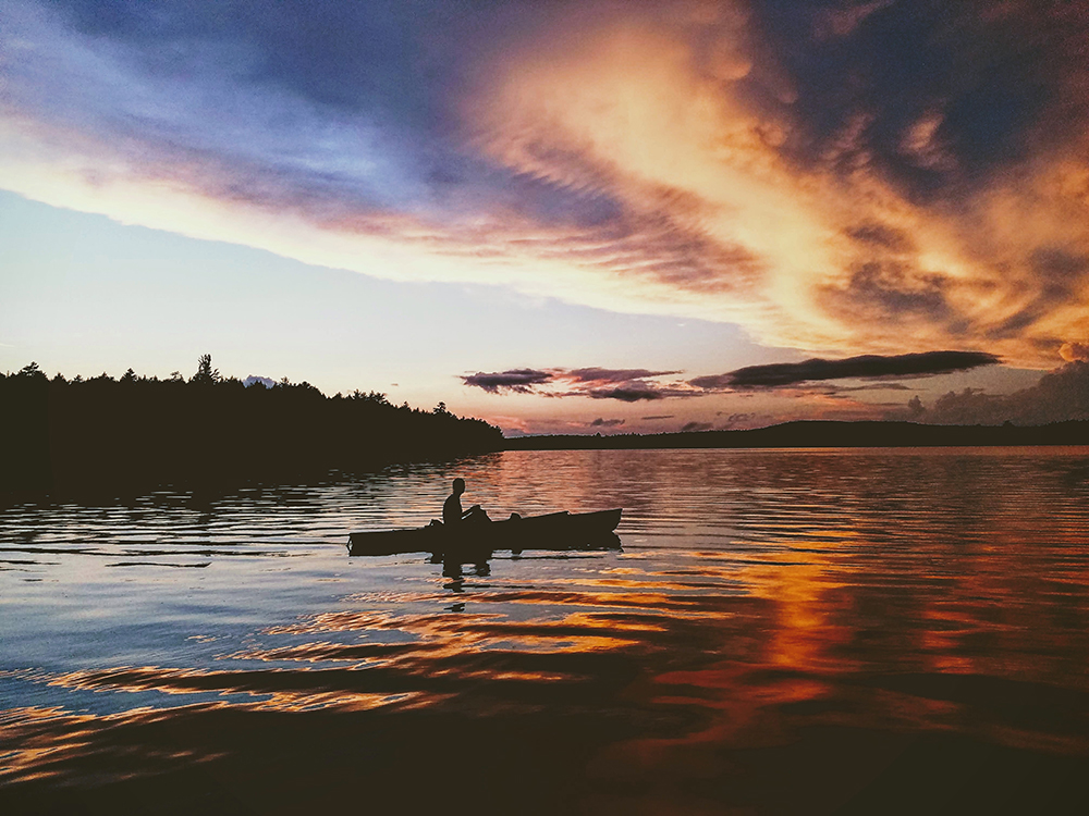 Boaters at dusk at a solar-lit put-in